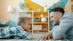 Vater und Sohn liegen auf dem Boden und reden miteinander