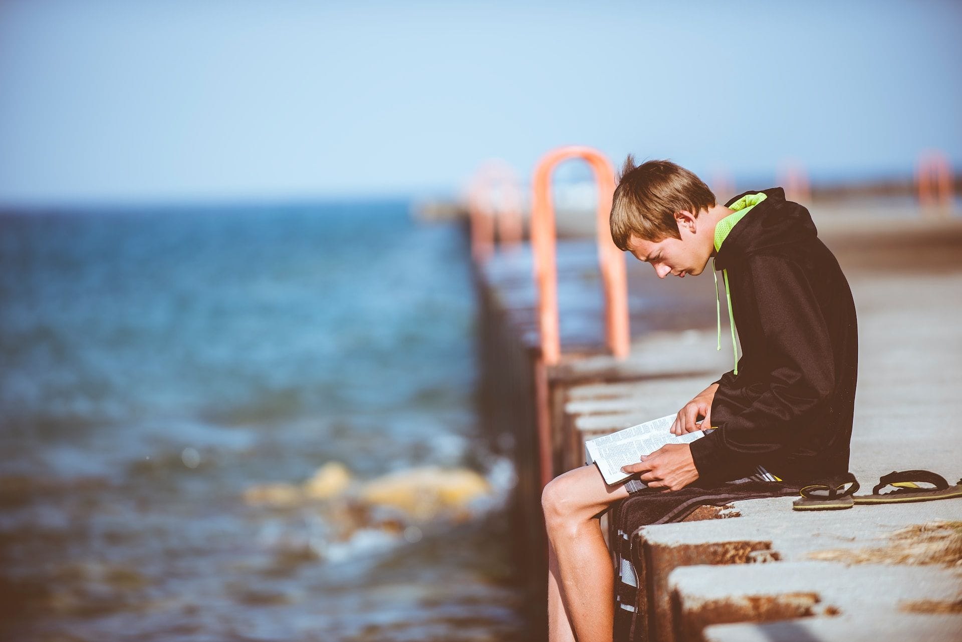 Un adolescente que lee la Biblia
