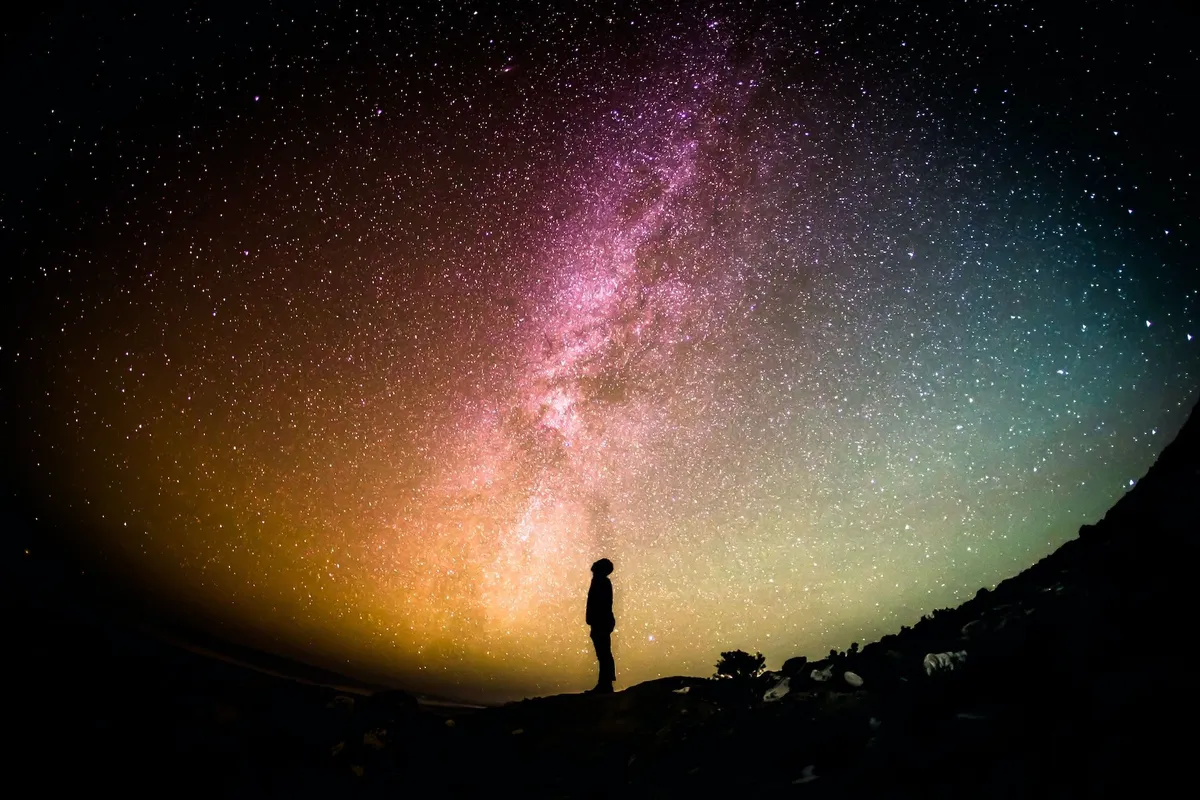 Silueta de una persona bajo un cielo estrellado