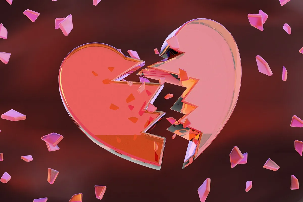 Un corazón roto rodeado de confeti rosa