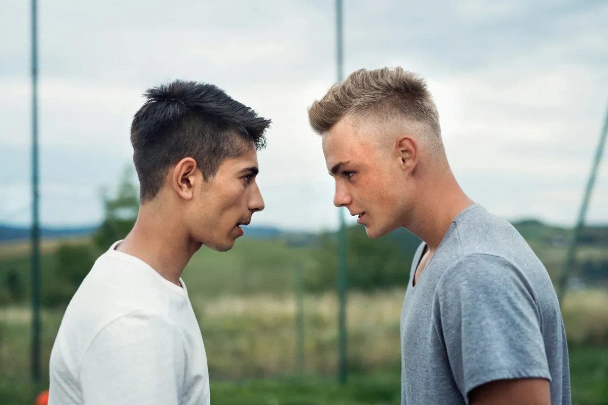 Dos adolescentes frente a frente se desafían con la mirada