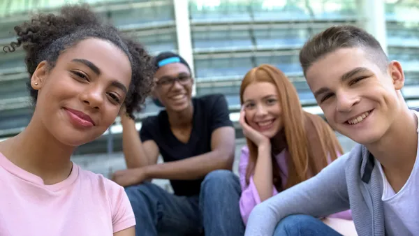Un grupo de amigos adolescentes sonríe a la cámara