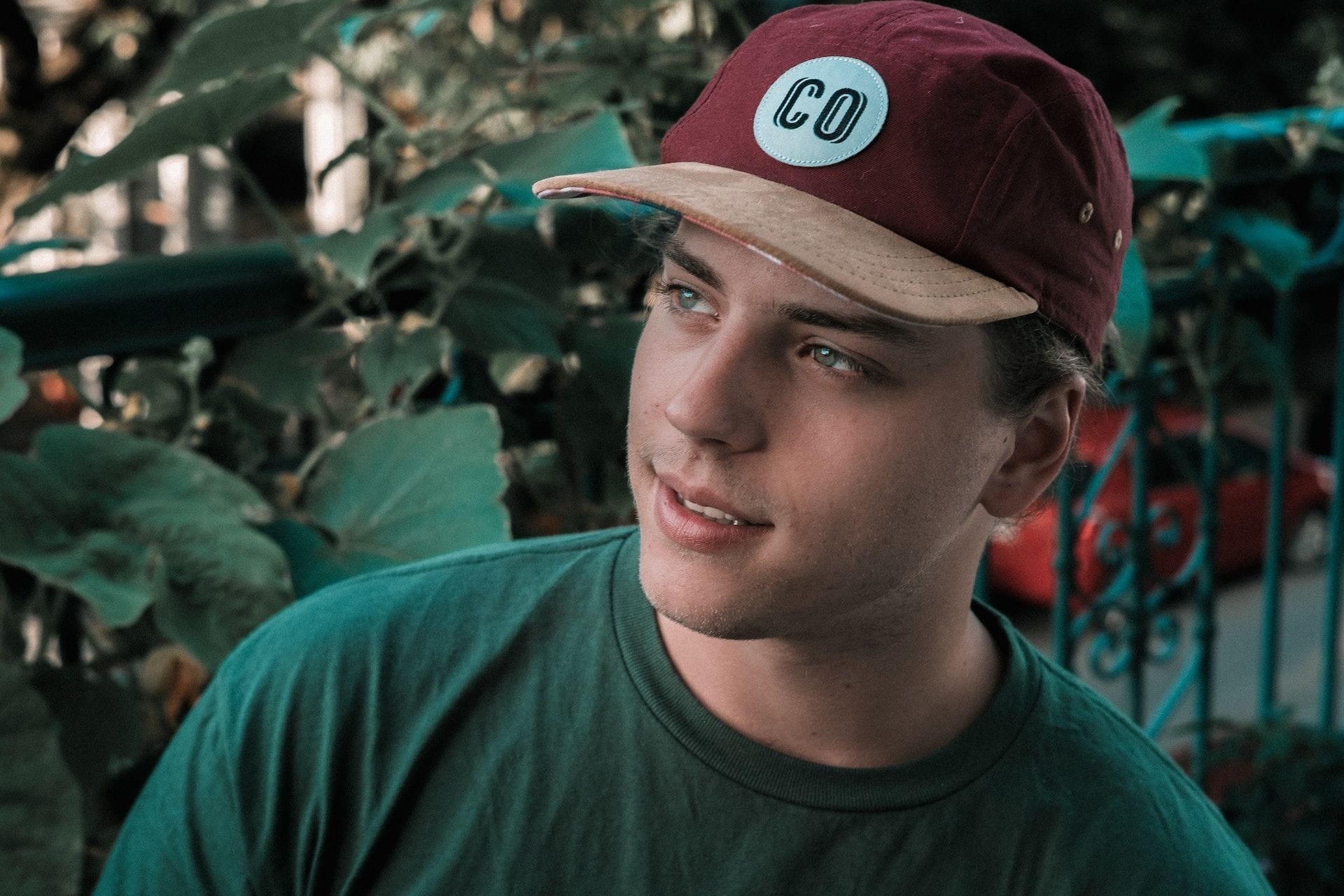 Un jeune homme avec une casquette rouge et un haut vert