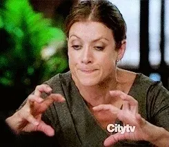 Une femme furieuse se penche vers quelqu’un, les mains crispées comme des griffes
