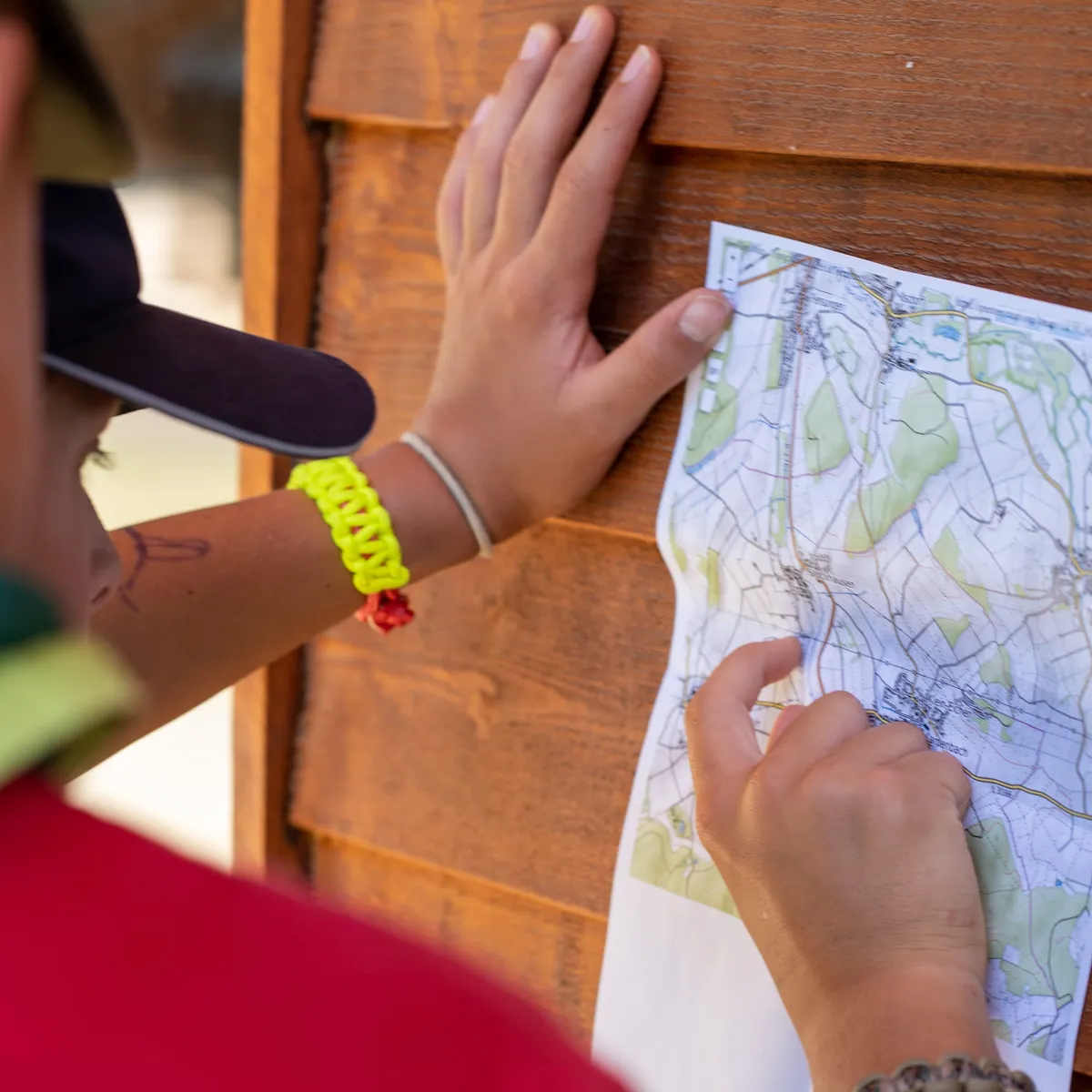 Des scouts préparent leur itinéraire de randonnée sur une carte
