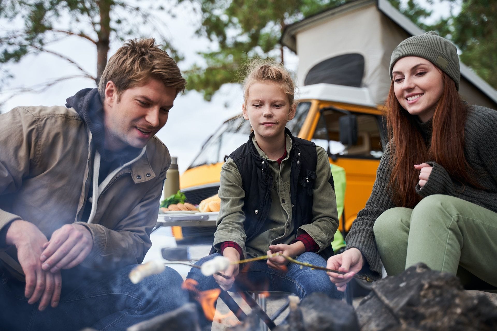 Familie la camping, prăjind bezele la foc