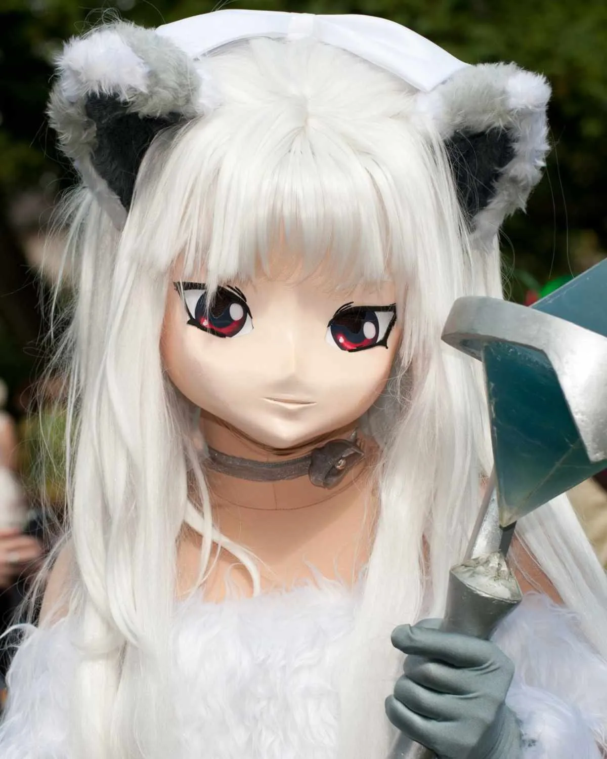 Persoană costumată ca un personaj anime, cu mască, perucă albă lungă și urechi de pisică