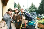 Un grup de tineri stând unul lângă altul, în aer liber